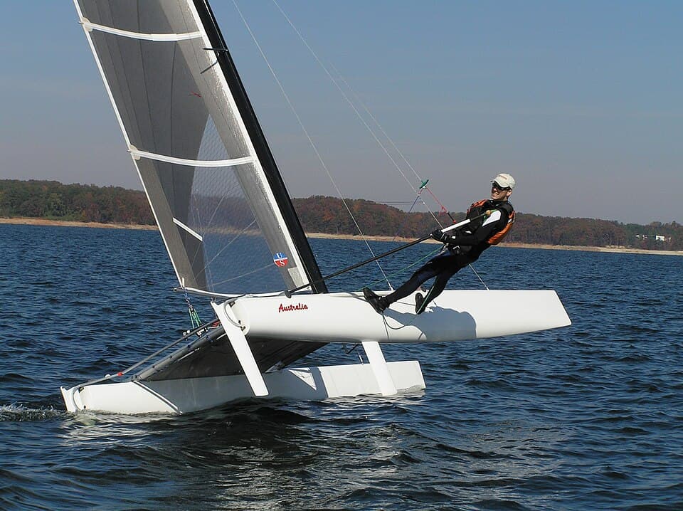 Sailor trapezing on a Boyer A-Class catamaran