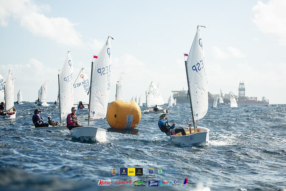 Optimist dinghies sailing around a race mark